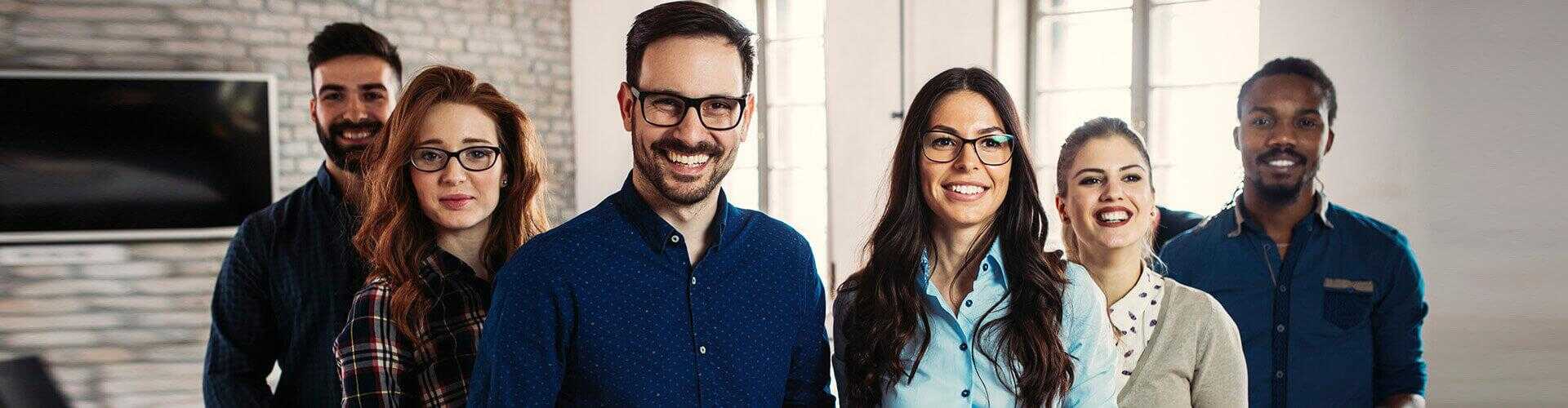 Programa Porque Somos Asi - Grupo de personas en fila sonriendo unas al lado de otras en la oficina